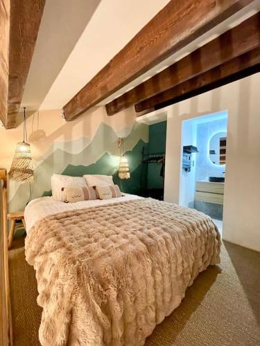 une chambre avec un grand lit dans une pièce dans l'établissement Duplex terrasse Randonnée Montagne La Foux d'Allos 4 à 6 Pers, à Allos