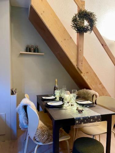 - une table à manger avec des chaises et une bouteille de vin dans l'établissement Duplex terrasse Randonnée Montagne La Foux d'Allos 4 à 6 Pers, à Allos