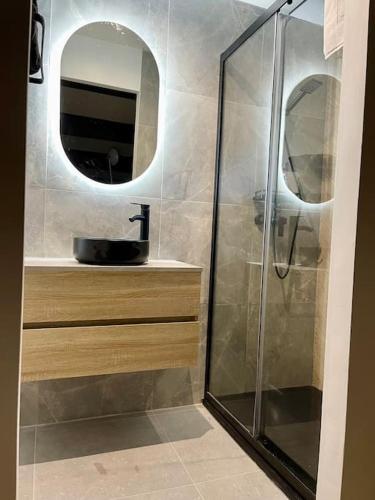 une salle de bain avec une douche avec un lavabo et un miroir dans l'établissement Duplex terrasse Randonnée Montagne La Foux d'Allos 4 à 6 Pers, à Allos