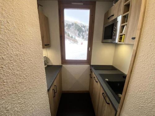 une petite cuisine avec une fenêtre et un évier dans l'établissement Résidence Arpasson - ARPASSON 69 MAE-6291, à Les Allues