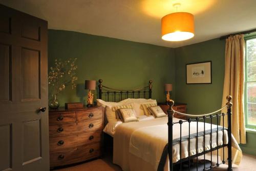 a bedroom with a bed and a dresser and a window at The Writer's House in Canterbury