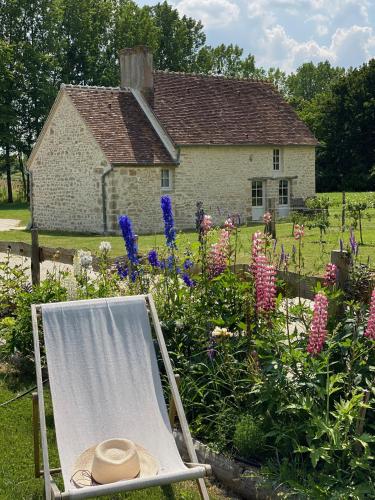 une chaise avec chapeau assise en face d'un jardin dans l'établissement Domaine de La Lipomerie - LA PETITE MAISON, à Gâprée