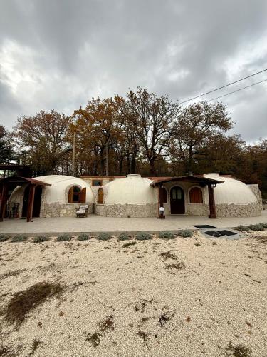 a couple of yurt houses with trees in the background at Miele B&B in Vinchiaturo