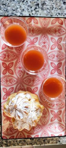 a tray with three glasses of orange juice on it at Villa Giummarito in Scicli