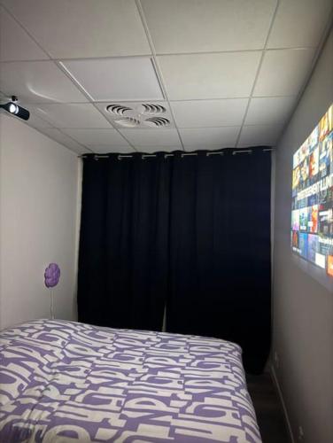 - une chambre avec un lit et un rideau noir dans l'établissement Chambre indépendante, à Muret