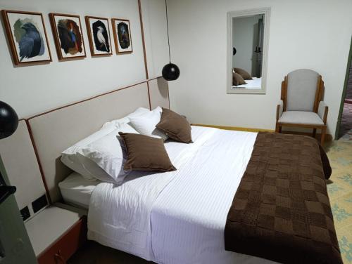 a bedroom with a large white bed and a chair at HOTEl NUSS in San Roque