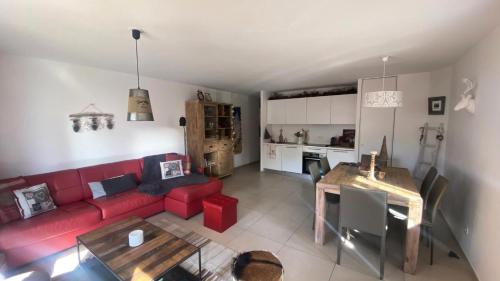 un salon avec un canapé rouge et une table dans l'établissement Résidence Grange Catharina - Superbe appartement a proximité des pistes et des commerces MAE-7704, à Montgenèvre
