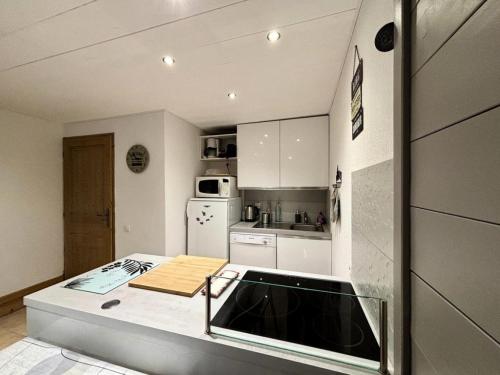 une cuisine avec des armoires blanches et un comptoir dans l'établissement Les Chalets De Wengen - CHALETS DE WENGEN A05Bis MAE-0841, à La Plagne Tarentaise