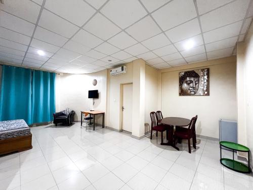 a hospital room with a table and chairs at Hotel Les Fleurettes in Ouagadougou