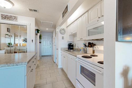 a kitchen with white cabinets and white appliances at Sunset Harbor Palms 1-308 in Navarre