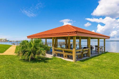 a gazebo with a table and benches next to the water at Sunset Harbor Palms 1-308 in Navarre