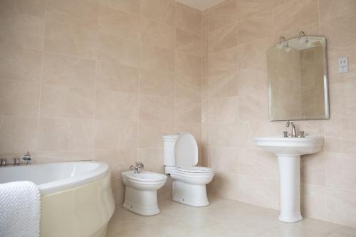 a bathroom with a tub and a toilet and a sink at Tara Manor - Family gathering's & hen parties in Omagh