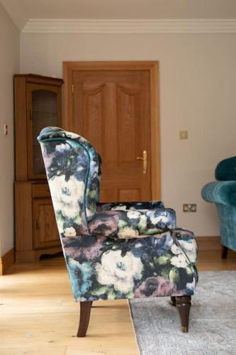 a blue and white chair sitting in a living room at Tara Manor - Family gathering's & hen parties in Omagh