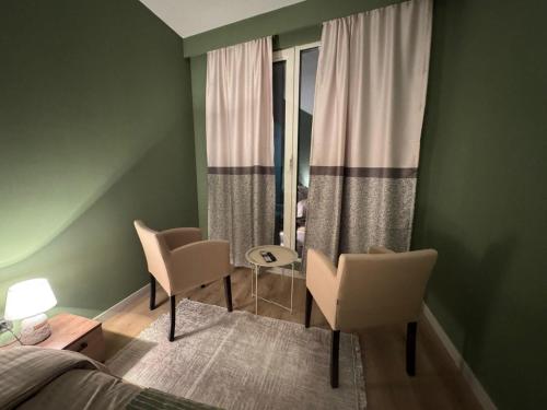 a bedroom with a bed and two chairs and a window at Sky Lux Point in Skopje