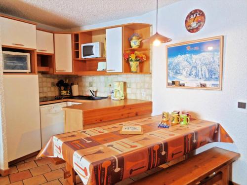 une cuisine avec une table et un comptoir dans l'établissement Résidence La Clef - Appartement 3 pièces pour 8 personnes de 49m² MAE-3831, à La Plagne Tarentaise