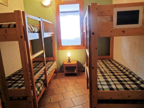 une chambre avec trois lits superposés et une fenêtre dans l'établissement Résidence La Clef - Appartement 3 pièces pour 8 personnes de 49m² MAE-3831, à La Plagne Tarentaise