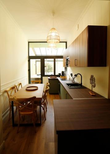 une cuisine avec une table et une salle à manger dans l'établissement L'arbre d'or Appart hyper centre spa couvert, à Cambrai