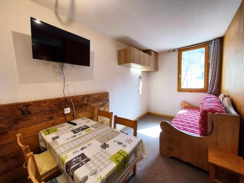 Cette petite chambre comprend une table et un canapé. dans l'établissement Résidence Le Zig Zag - ZIG ZAG 27 MAE-3841, à La Plagne Tarentaise