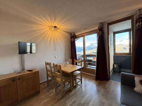 une salle à manger avec une table et une télévision dans l'établissement Résidence L'equerre - Appartement 2 pièces pour 4 personnes de 25m² MAE-3891, à La Plagne Tarentaise