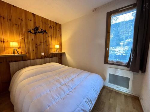une chambre avec un lit blanc et une fenêtre dans l'établissement Résidence L'equerre - Appartement 2 pièces pour 4 personnes de 25m² MAE-3891, à La Plagne Tarentaise