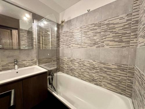 une salle de bain avec une baignoire blanche et un lavabo dans l'établissement Résidence L'equerre - Appartement 2 pièces pour 4 personnes de 25m² MAE-3891, à La Plagne Tarentaise