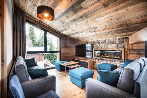 un salon avec des chaises bleues et une cheminée dans l'établissement Résidence OrÉe Du Bois - APPARTEMENT N°6 L'OREE DU BOIS MAE-9671, à Montvalezan