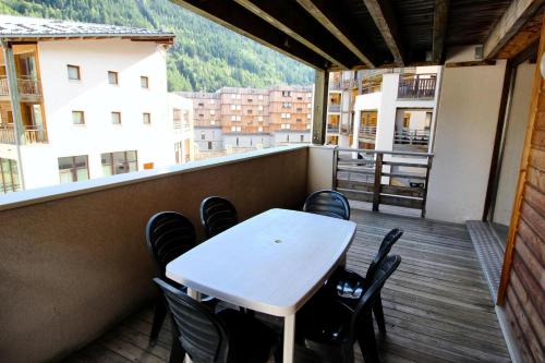 une table blanche et des chaises sur un balcon dans l'établissement Chalets De La Vanoise - LES CHALETS DE LA VANOISE-CV3103 MAE-4531, à Villarodin-Bourget