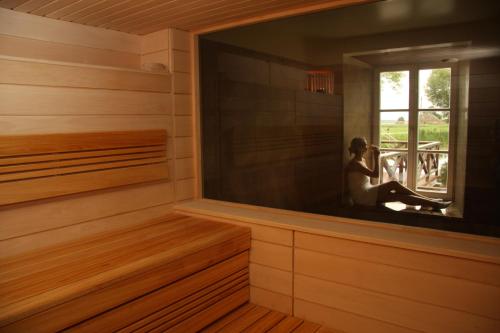 a sauna with a woman sitting in a window at Bistrampolis Manor in Kučiai