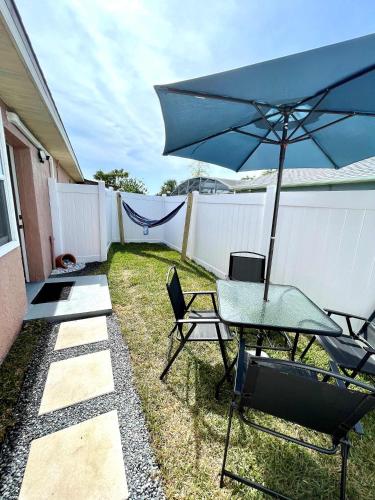 a patio with a table and chairs and an umbrella at NEW5 LUXURYSTUDIO Nr DISNEY PETSOKprivENTRY in Kissimmee