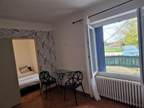 a room with a window and two chairs and a table at Une maison avec 3 chambres in Bédarrides
