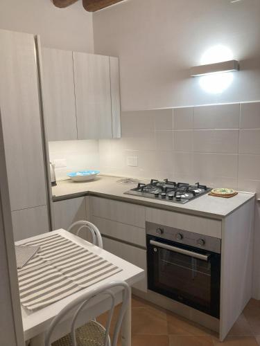 uma pequena cozinha com um fogão e uma mesa em Marconi La Casetta em Panicale