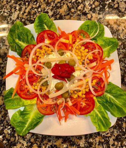a plate of food with vegetables on a table at Mirador de Miranda, Apartamentos Rural & Spa Inc in Cutiellos