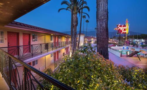 a view of a resort with a pool at night at Safari Inn, a Coast Hotel in Burbank