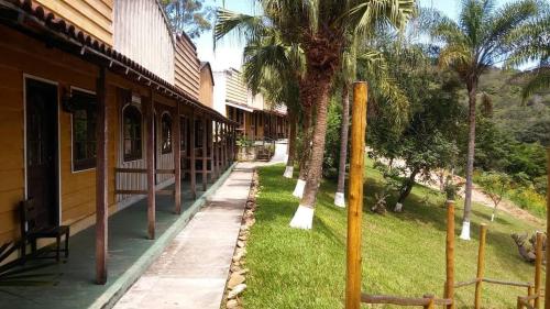 a building with palm trees next to a sidewalk at Old West Hotel Fazenda in Tremembé