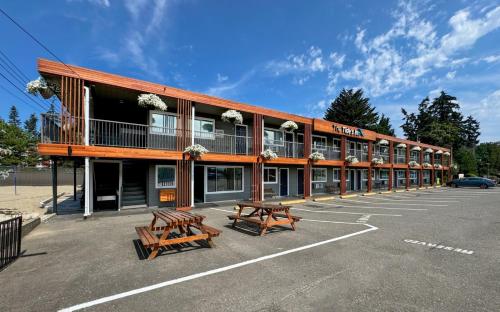 un bâtiment avec deux bancs dans un parking dans l'établissement The Tide's Inn, à Parksville