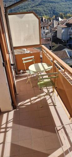 a balcony with a table and chairs on a building at Au coeur de Vizille in Vizille