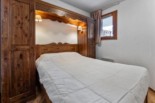 une chambre avec un grand lit avec une tête de lit en bois dans l'établissement Résidence Les Hauts De Preclaux - Appartement de montagne pour 8 personnes MAE-3691, aux Orres