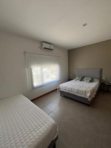 a bedroom with two beds and a window at La Morada Apart in Cafayate