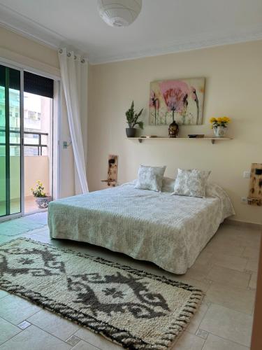 a bedroom with a large bed and a rug at Ibn elkhatib B in Tangier