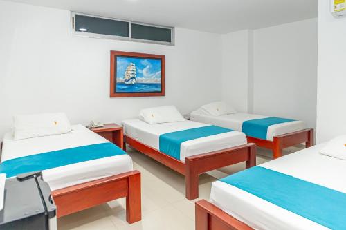 a room with three beds in a room at Hotel Aguamarina in Santa Marta