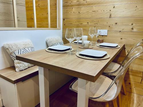 - une table en bois avec des verres à vin et des serviettes dans l'établissement Studio entièrement rénové au pied du télésiège du Diable, à Les Deux Alpes