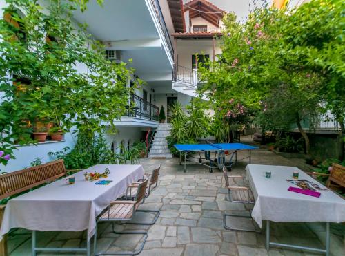 a patio with tables and chairs and trees at Pension Aldebaran in Potos