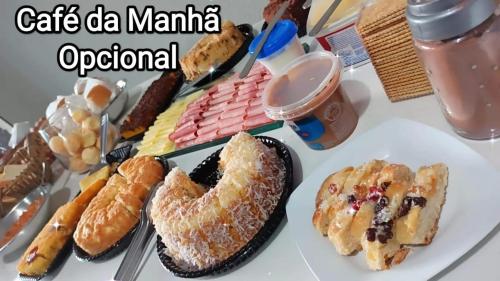 a table with a plate of pastries and other desserts at Pousada Apucarana - Sede in Apucarana