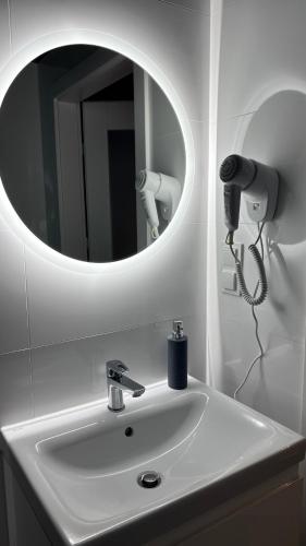 a bathroom with a white sink with a mirror at Apartament Pogodny in Chojnice