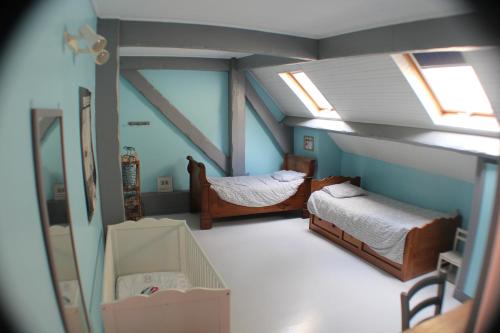 a attic room with two beds and a crib at Chambres d'hôtes les Marronniers in Bordeaux
