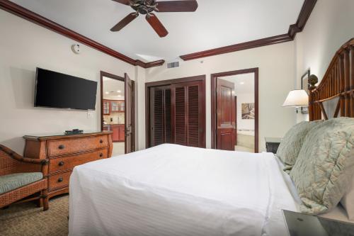 a bedroom with a bed and a flat screen tv at Waipouli Beach Resort and Spa Kauai by OUTRIGGER in Kapaa