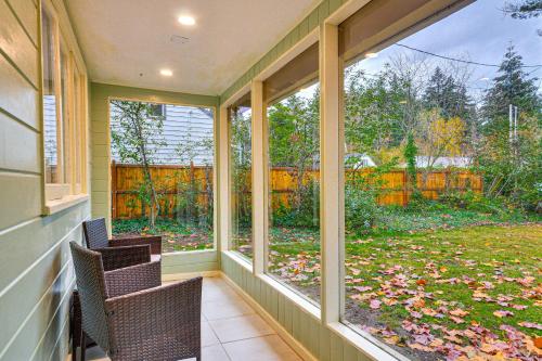 a screened porch with two chairs and a view of a yard at Modern Home with Spacious Yard in Beaverton! in Beaverton