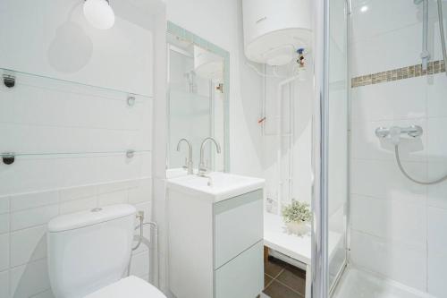 een witte badkamer met een toilet en een wastafel bij Amelie in Paris in Parijs