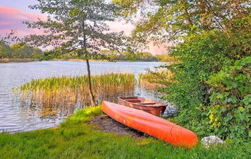 a red canoe sitting on the shore of a lake at Ferienwohnung Klocksin in Blücherhof