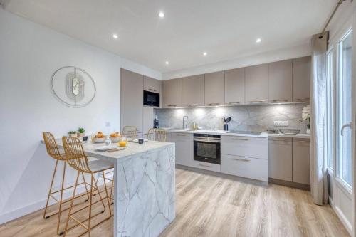 a kitchen with white cabinets and a table and chairs at #HE The Golden Escape Ile Verte luminous renovated in Grenoble
